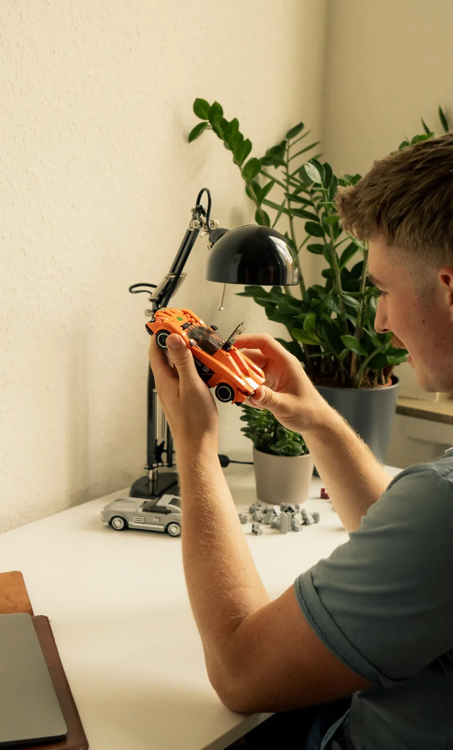Ein junger Mann, der ein Klemmbaustein Auto Set von Penny Bricks in den händen hält